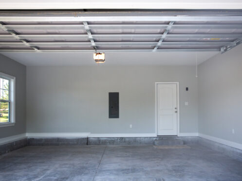 Empty large two-car garage with cement floors